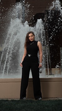 a woman posing in front of a fountain