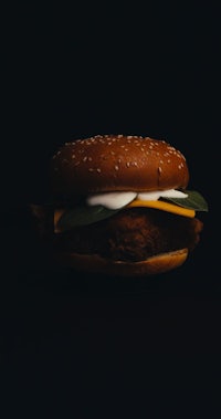 a mcdonald's chicken burger on a black background