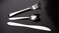 a spoon, fork and knife on a black surface